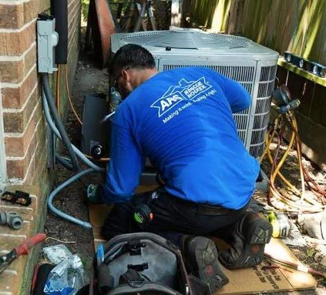 Technician checking connections beside an outdoor condenser